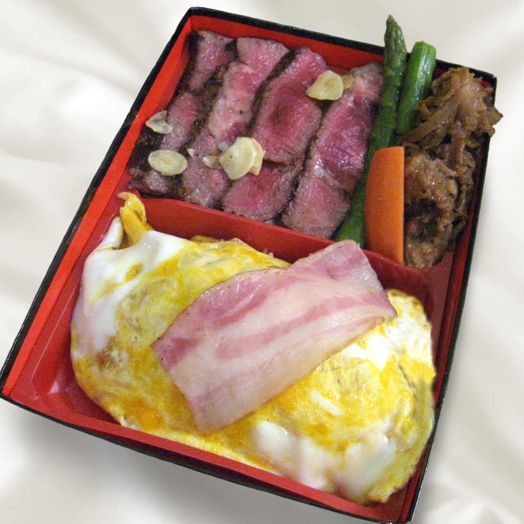 A bento box with sliced steak, garlic, asparagus, sautéed vegetables, an omelette, and bacon on rice.