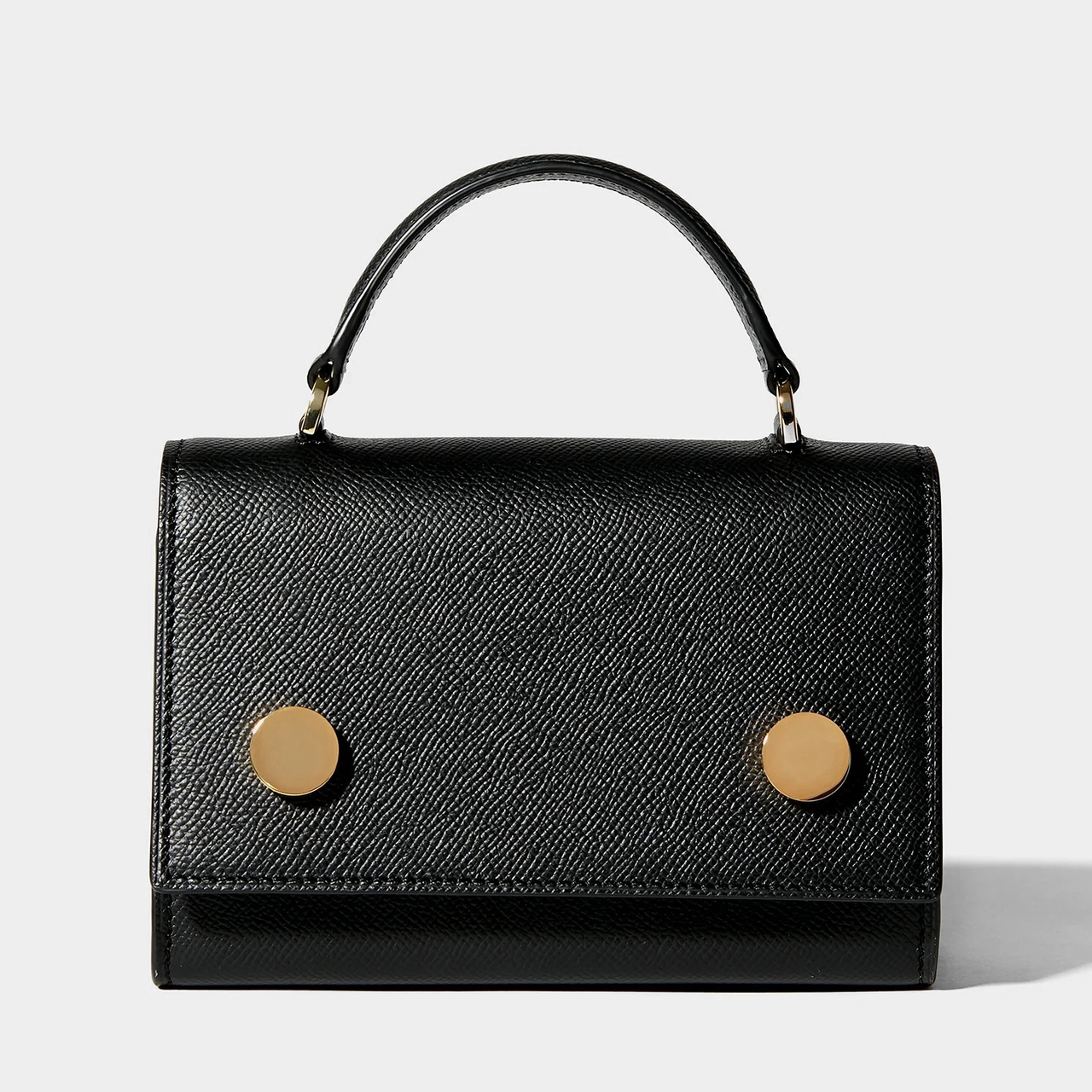 Black leather handbag with a top handle, featuring two large gold buttons on the front.