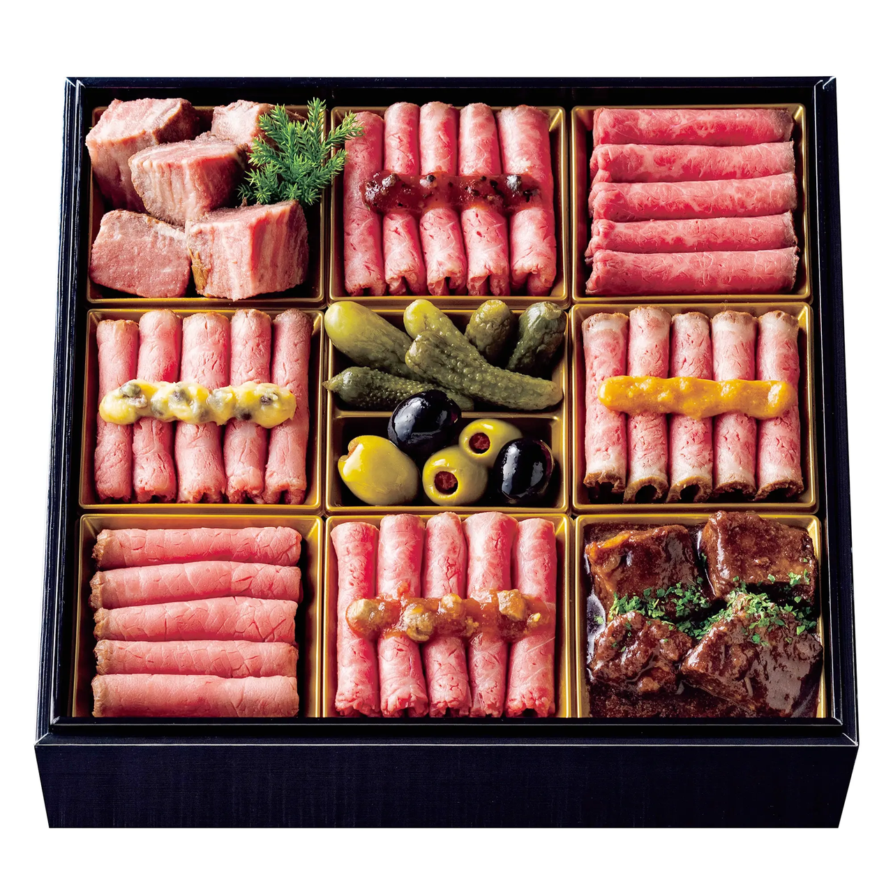 A bento box with various cured meats, pickles, and olives, neatly arranged in separate compartments for an elegant presentation.