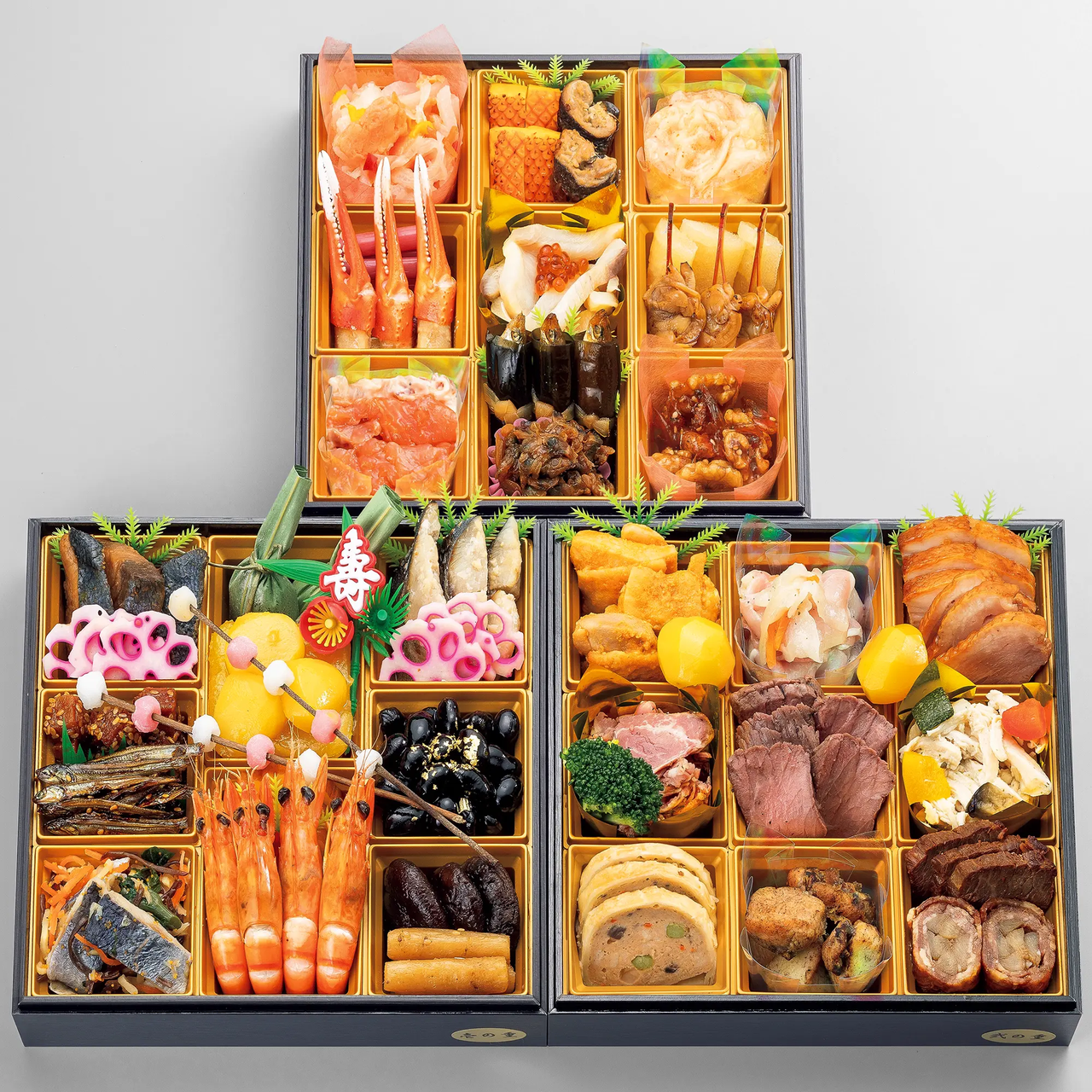 A colorful and neatly arranged Japanese osechi box filled with a variety of traditional New Year dishes, including seafood, meats, and vegetables.