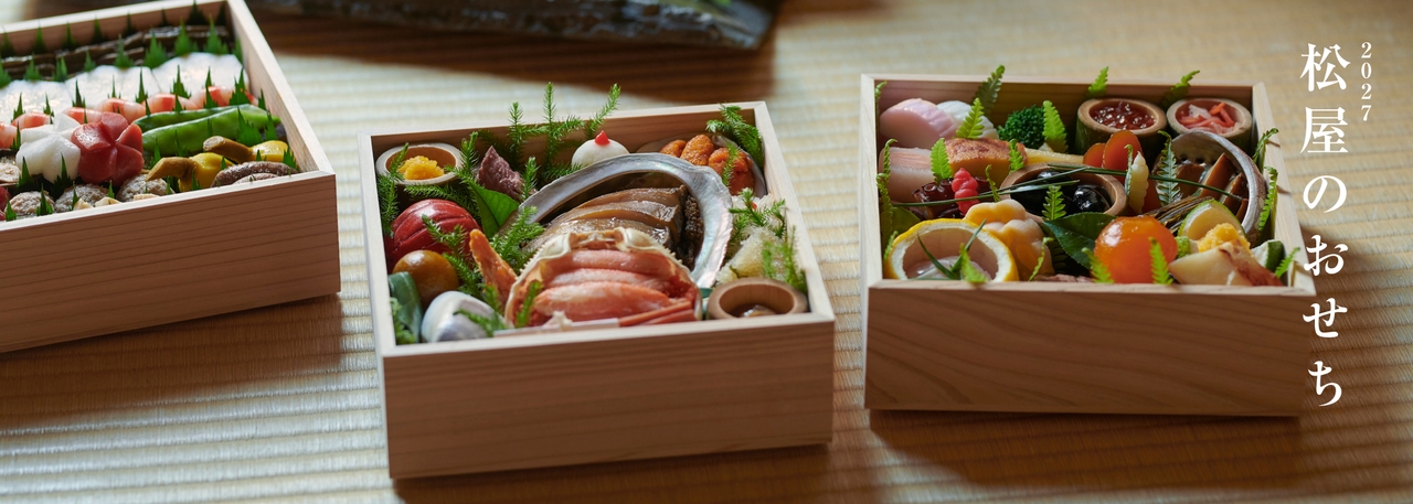 木製のテーブルの上に、色とりどりの魚介類や野菜が盛り付けられた、伝統的な日本のおせちの重箱が並んでいる。側面には「2027松屋のおせち」のロゴ。
