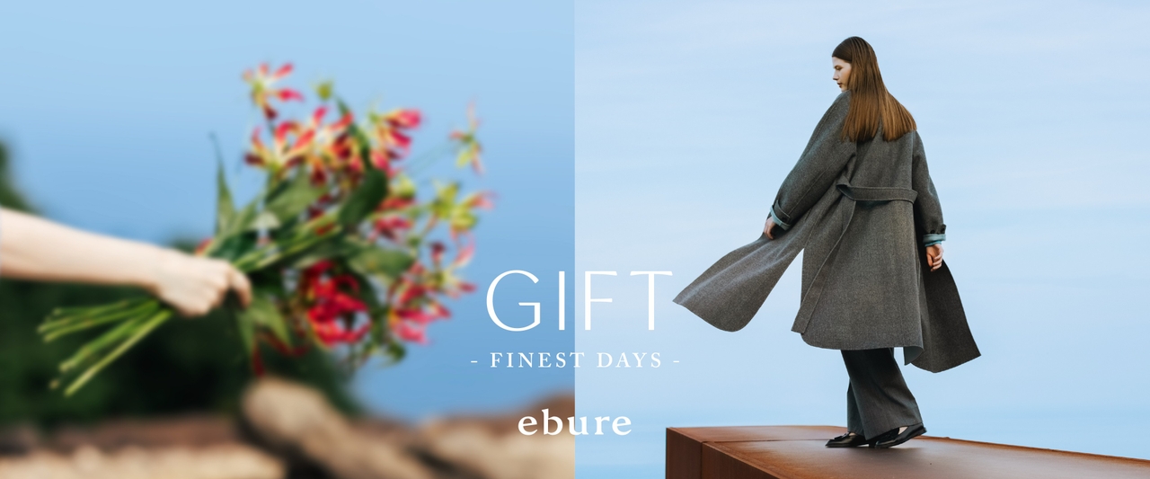 左側に赤い花を持つぼかした手、右側にグレーのコートを着た女性。「GIFT - FINEST DAYS」〈ebure〉