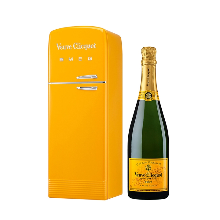 Yellow mini fridge with "Veuve Clicquot" branding beside a matching bottle of Veuve Clicquot champagne.