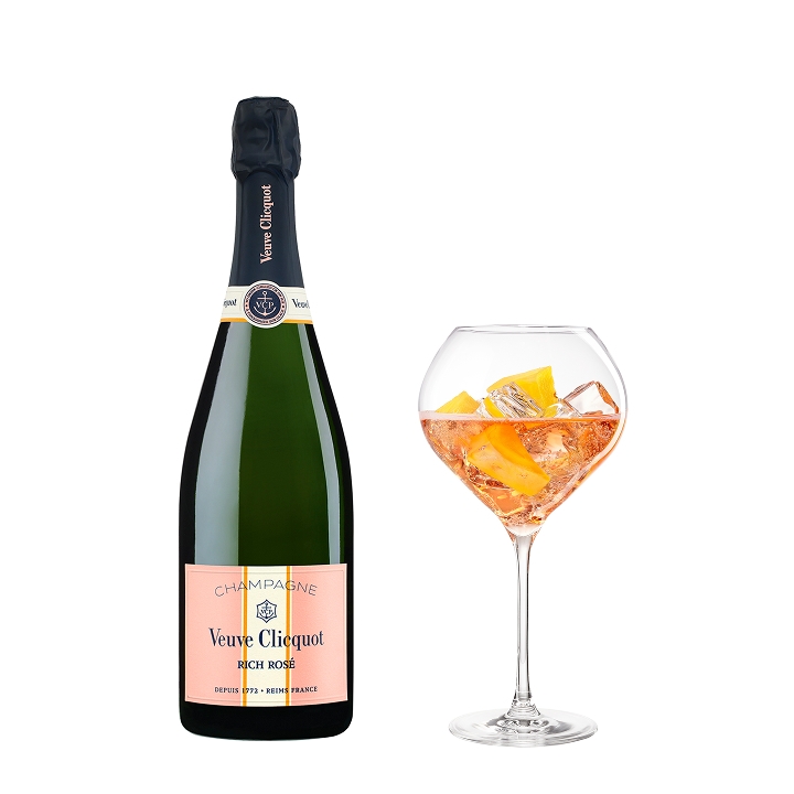 Veuve Clicquot  Rich on Ice Rosé champagne bottle next to a glass filled with pink champagne and orange slices.
